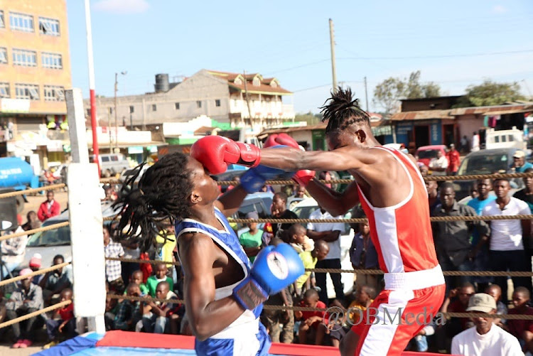 Francis Njoroge (red) Ongata Rongai Boxing Club dishes out a brutal jab to Victor Mwanthi (blue) of Beasthouse Boxing Club in the Lightweight finals in the Kajiado Intermediates in Ngong Town