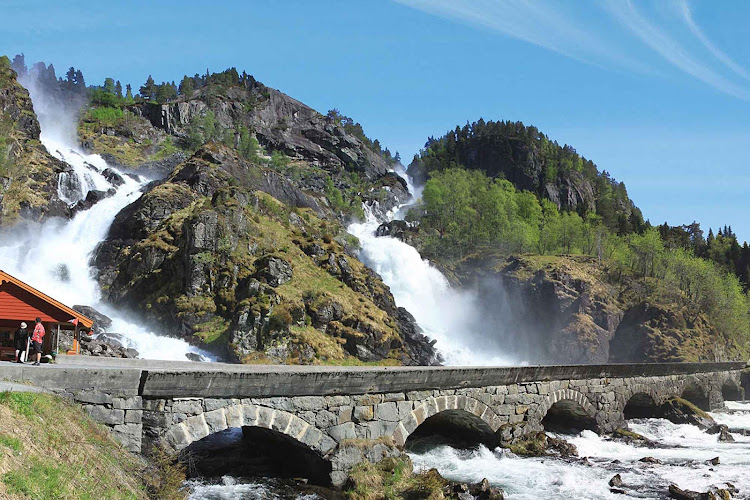 The spectacular Latefossen waterfall splits apart then comes together before going under the arched bridge. Latefossen is near Oda, Norway, southeast of Bergen.