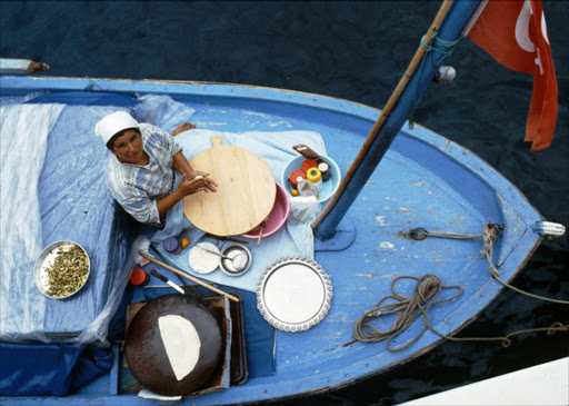 A woman makes savoury pancakes for tourists heading to the fine beach at Butterfly Valley