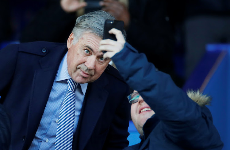 Everton manager Carlo Ancelotti takes a selfie with a fan before a recent match