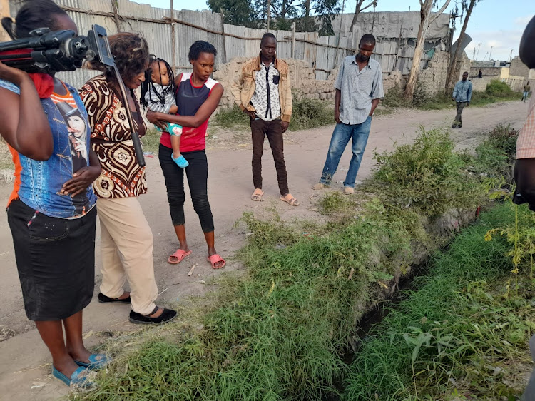 Residents at the scene where the girl's body was discovered dumped in a trench at Orata area in Kitengela, Kajiado County on Wednesday, June 2.