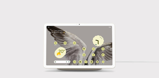 Close-up of Pixel Tablet displaying a home screen featuring the date and time and the brilliant detail of a bird wing background.