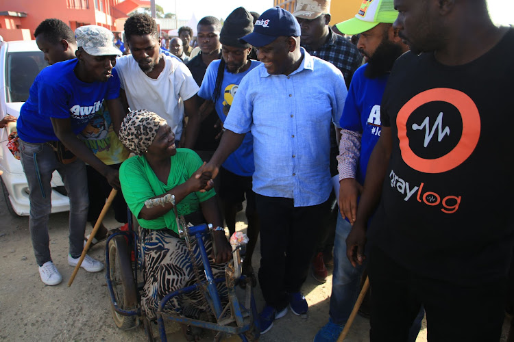 Former Nyali MP Hezron Awiti with Kwa Bulo residents at Kwa Bulo Primary School on Sunday.