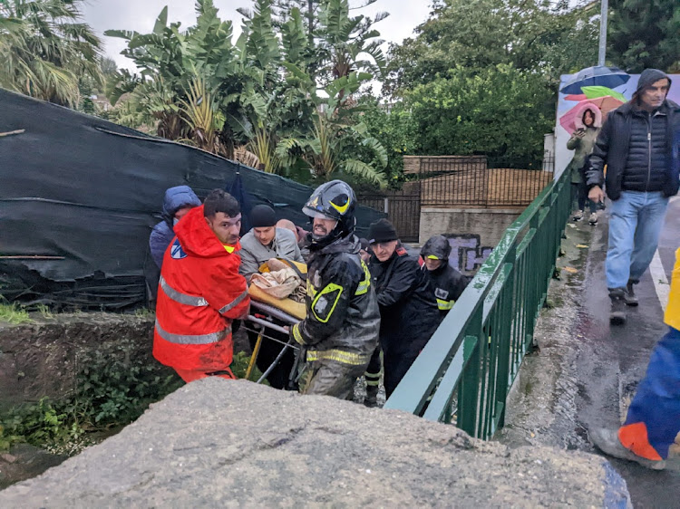 Rescuers help an injured person following a landslide on the Italian holiday island of Ischia, Italy.