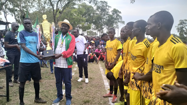 ODM leader Raila Odinga hands over a trophy to Ndiru FC after winning in Opira Biannual tournament at Ndiru in Homa Bay Town constituency on December 29,2023