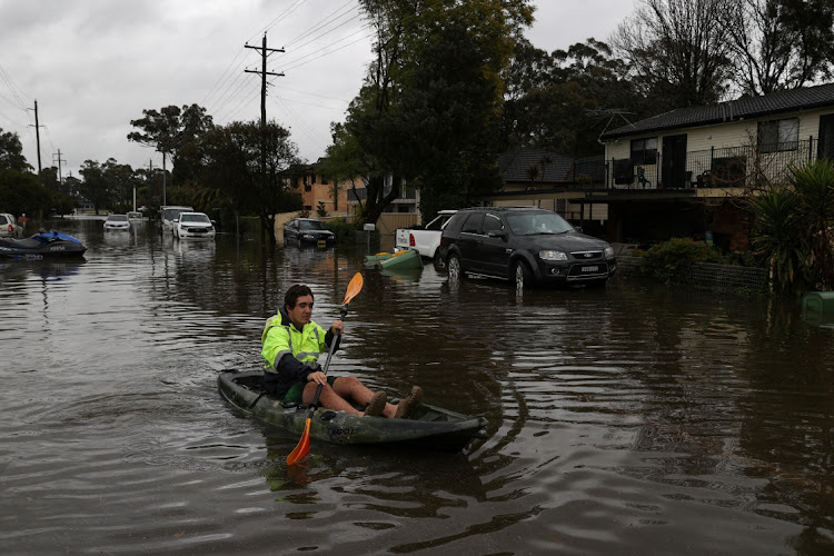 A kayaker paddles through a flooded residential area following heavy rains in the South Windsor suburb of Sydney, Australia on July 5 2022. Picture: REUTERS/LOREN ELLIOTT