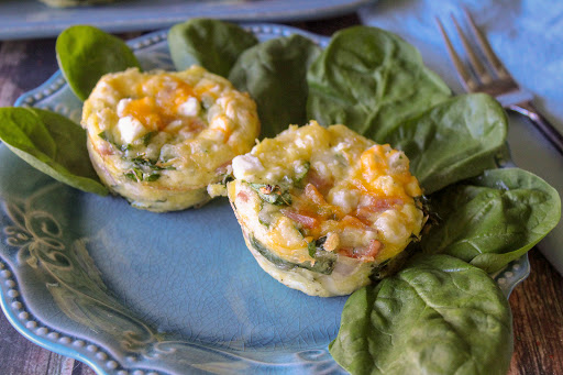 Two ham & cheese low carb breakfast muffins on a plate.