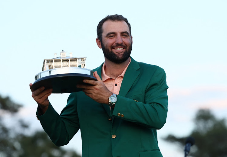 Scottie Scheffler of the US celebrates with his green jacket and the trophy after winning The Masters at Augusta National Golf Club on April 14, 2024