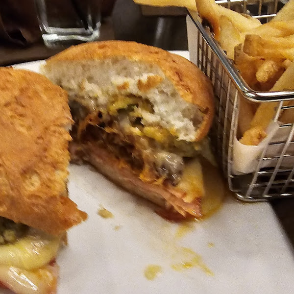 Cuban with fried pickles on board and fries.