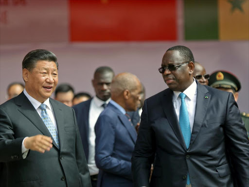 Senegal's President Macky Sall and Chinese President Xi Jinping talk as they enter the stadium during the opening ceremony for the Arene Nationale du Lutte, the Arene Nationale du Senegal in Dakar, Senegal July 22, 2018. /REUTERS