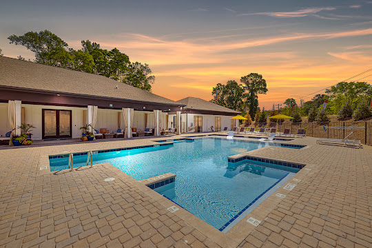 Pointe Grand Spartanburg's swimming pool at dusk with large sundeck featuring cabanas