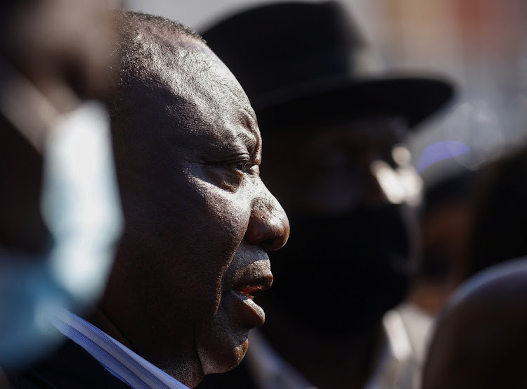 President Cyril Ramaphosa speaks to the media while visiting a shopping centre damaged after several days of looting following the imprisonment of former president Jacob Zuma.