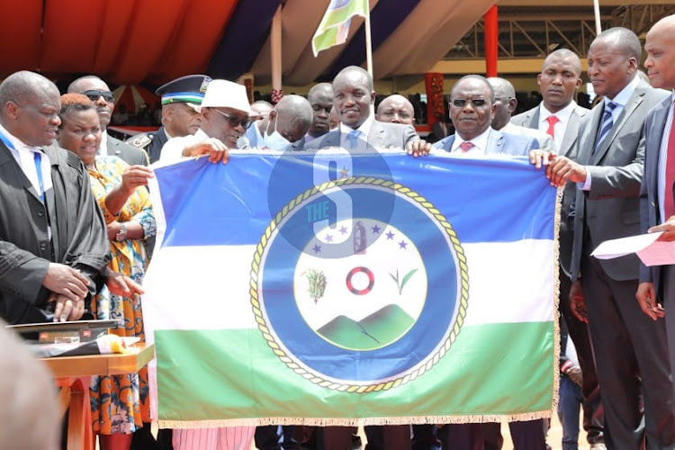 Outgoing Governor James Ongwae hands over instruments of power to incoming Governor Simba Arati at Gusii stadium.