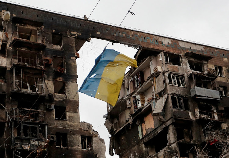 A torn Ukrainian flag hangs defiantly in front an apartment building destroyed by the Russian attack on Mariupol. 'It was terrible... like films that show the last days of the planet – the same thing happened here,' said one resident of the city, Viktoria Nikolayeva, 54, who, like many others, took shelter in a basement.