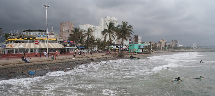 Surfers paddle along what remains of the Golden Mile near Dairy Beach. Image: Tony Carnie