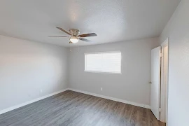 Bedroom with wood inspired flooring, a window, and a ceiling fan