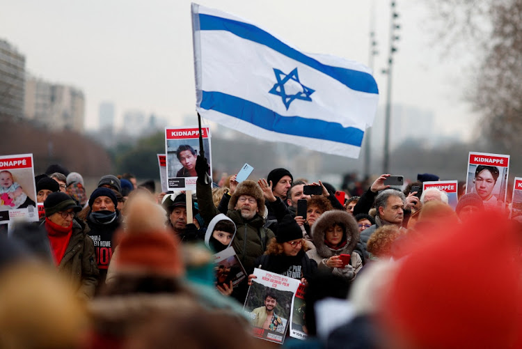 A man holds an Israeli flag as people gather during the event "100 days 100 voices" to mark 100 days since the October 7 Hamas attack, calling for the release of Israeli hostages in Gaza, in front of the Opera Bastille in Paris, France, on January 14 2024.