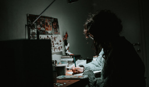 Man drawing at desk late at night