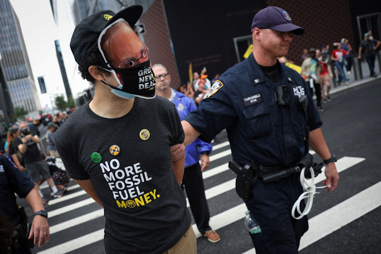 A climate activist is detained by a New York City Police Department (NYPD) officer as demonstrators blocked vehicle traffic during a protest outside the headquarters of Blackrock in Manhattan in New York City, New York, US, September 13, 2023.