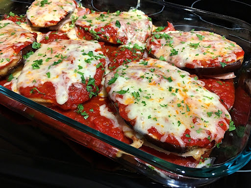 Beautiful baked chicken breasts topped with prosciutto then eggplant, marinara sauce and cheese plus garnish with fresh chopped parsley