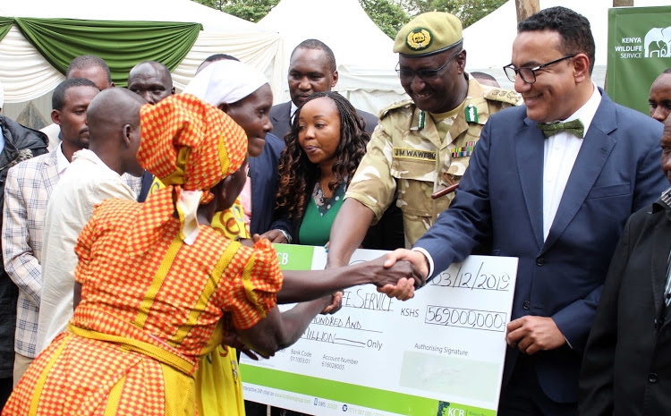 CONSOLATION: Tourism CS Najib Balala with cheque to compensate human-wildlife victims on December 3, 2019. Maureen Ouko represented the victims Image: /Andrew Kasuku