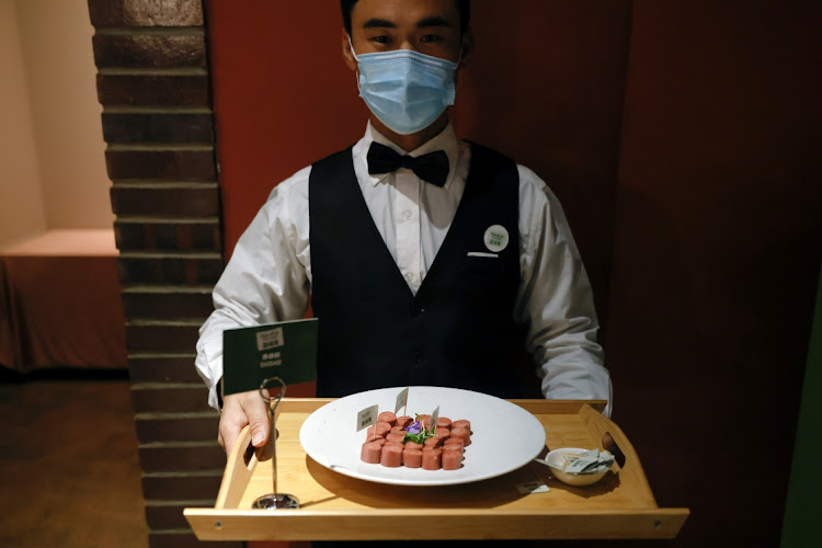 A waiter with Nestlé plant-based sausages from the Harvest Gourmet line during the launch event in Beijing, China, December 9 2020. Picture: REUTERS/THOMAS PETER