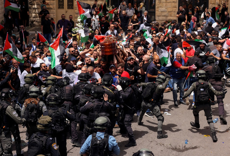 Family and friends carry the coffin of Al Jazeera reporter Shireen Abu Akleh, who was killed during an Israeli raid in Jenin in the occupied West Bank, as Israeli security forces beat and kicked pallbearers, during her funeral in Jerusalem on May 13 2022. Picture: REUTERS/AMMAR AWAD