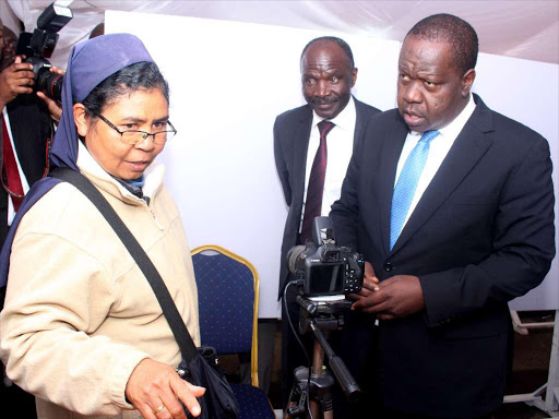 Immigration PS Gordon Kihalangwa and CS Fred Matiang’i talk to Mary Ninaleim from Indonesia at Nyayo House where they reviewed progress in verification and registration of work permits on July 3 /EZEKIEL AMING’A