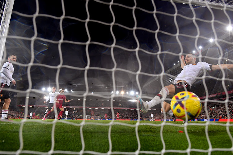 Mohamed Salah of Liverpool scores the team's seventh goal as Diogo Dalot of Manchester United attempts to clear the line during the Premier League match at Anfield in Liverpool on March 5 2023.