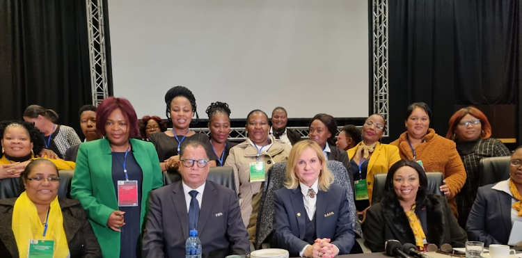 Safa president Danny Jordaan (wearing black suit with glasses) flanked by women from the association's different structures.