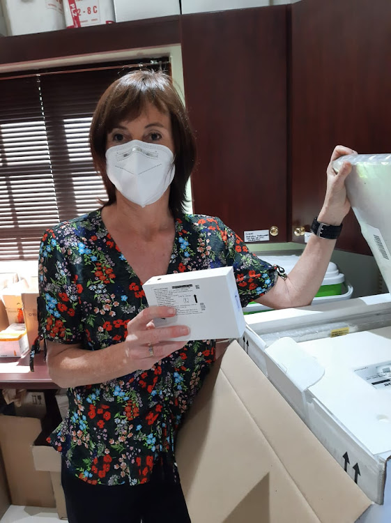 Phoenix Pharma head research pharmacist Paulette McEwan holds up a box of the vaccines to be used on Wednesday afternoon