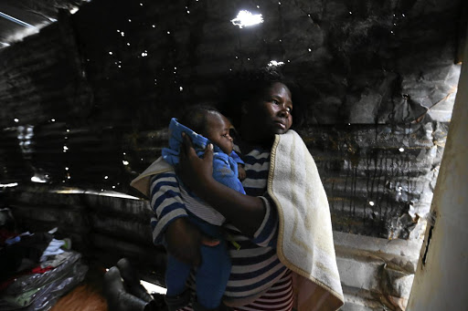 A WEEK FROM HELL: Siphokazi Mvumbi and her two-month-old son, Mnqubi, have been hit badly this week. A fire destroyed their home in Sydenham's Foreman Road informal settlement. Mvumbi has rebuilt her house, but has since had to contend with heavy rain that battered KwaZulu-Natal.