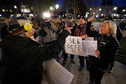 Protesters argue as they demonstrate outside The Kenosha County Courthouse, during the trial of Kyle Rittenhouse, in Kenosha, Wisconsin, U.S., November 15, 2021. REUTERS/Brendan McDermid