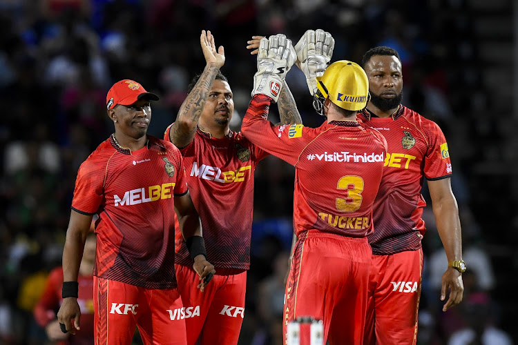 Sunil Narine (second from left), Dwayne Bravo (left) and Kieron Pollard (right) of Trinbago Knight Riders celebrate the dismissal of Joshua Da Silva of Saint Kitts and Nevis Patriots during their Caribbean Premier League match at Warner Park Sporting Complex in Basseterre, Saint Kitts and Nevis on Monday night. Narine later had to leave the field in the final over as Riders received a red card for a slow over rate.