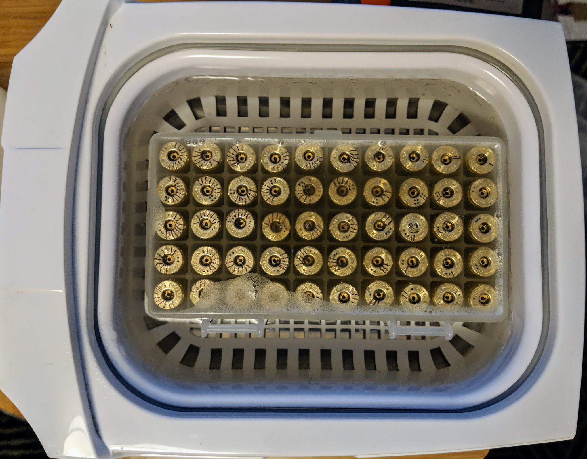 Ultrasonic cleaning brass cases while maintaining the order.