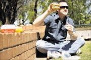 SCRUMPTIOUS: Steven van Niekerk enjoying a cheeseburger. Pic: Moeketsi Moticoe. 08/09/2009. © The Times.