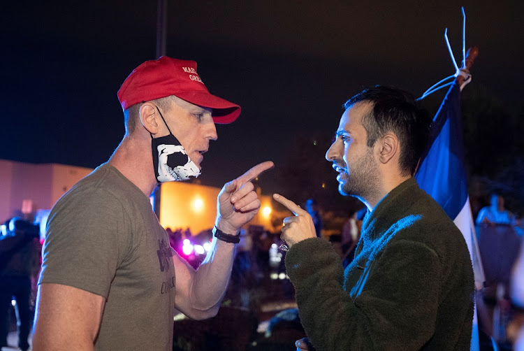 Supporter of US President Donald Trump (L) argues with a man holding a Democratic Party flag during a "Stop the Steal" protest at Clark County Election Center in North Las Vegas, Nevada, US on November 5, 2020.