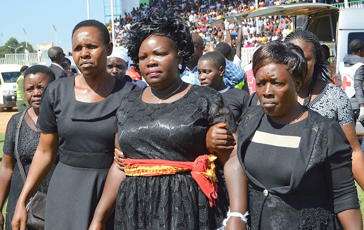 Mother of one of the 14 pupils who perished in Kakamega Primary School tragedy being assisted by relatives during the memorial service at Bukhungu Stadium Kakamega county on February 7, 2020