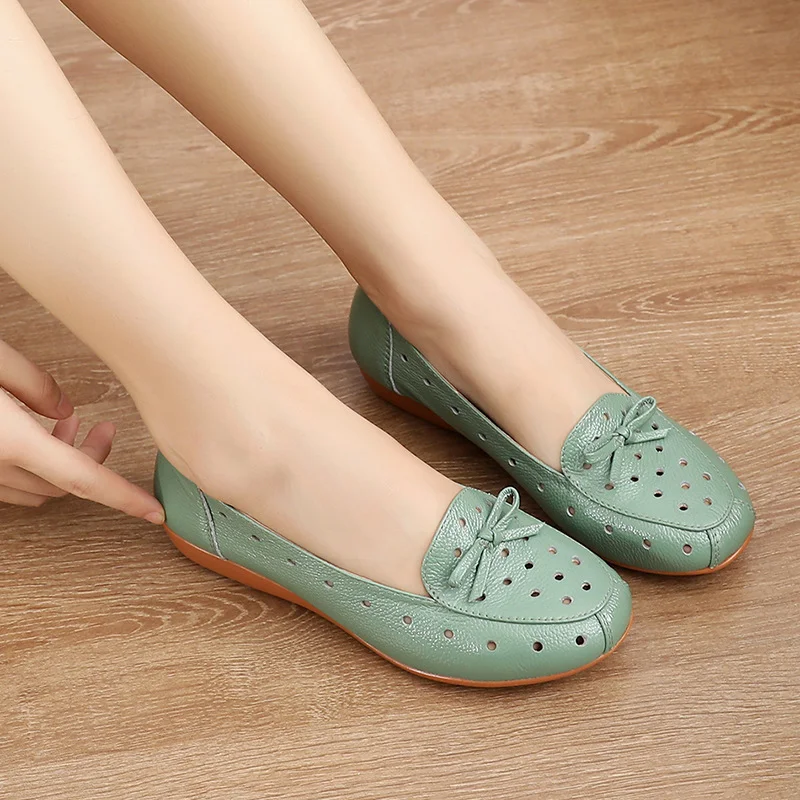 Sandales plates d'été en cuir ajouré pour femmes. Légères et aérées, ces chaussures offrent style et confort pour les chaudes journées.