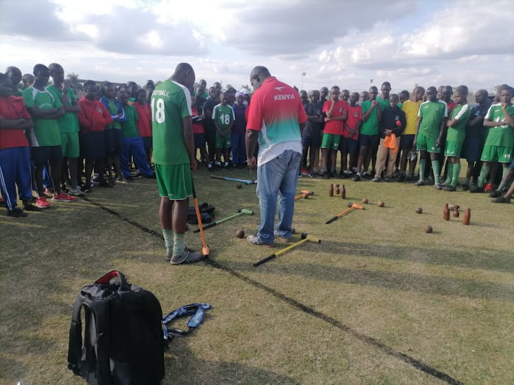 Kenya Woodball Federation coach Titus Mboya training one of his players.