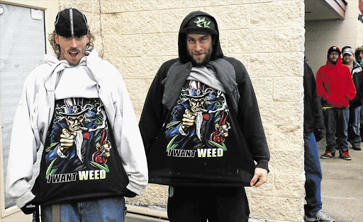 BLUNT STATEMENT: Mark Gordon, left, and Ryan Perry make their desires clear as they wait in line to be among the first to legally buy recreational marijuana at the Botana Care store in Northglenn, Colorado