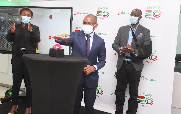 Chief Customer Officer Sylvia Mulinge and Human resource manager Paul Kasimu claps as Safaricom CEO Peter Ndegwa launch the reopening of Moi Avenue safaricom shop on December 9,2020