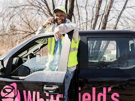 Smiling man on the phone by a vehicle