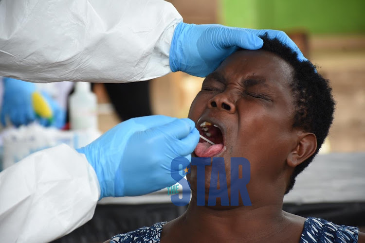 A sample is collected from Rose Wangari for Covid-19 test using a special swab at Biafra Medical Centre in Eastleigh on May 15