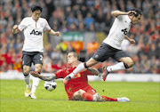 EMOTIONAL GAME: Liverpool's Daniel Agger, centre, is challenged by Manchester United's Shinji Kagawa, left, and Rafael during their Premiership match at Anfield in Liverpool on Sunday.
      Photo: REUTERS