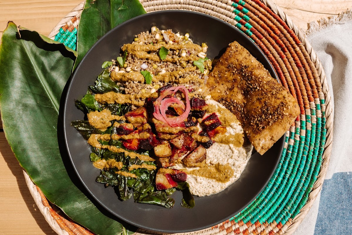 Mediterranean flavours abound in our seasonal (GF/VG) Hummus Bowl, made with chickpea hummus, kale, quinoa tabouleh, roasted local veg, topped with pickled onion and tumeric tahini dressing, served with our delicious homemade Gluten-free Za'atar flatbread.