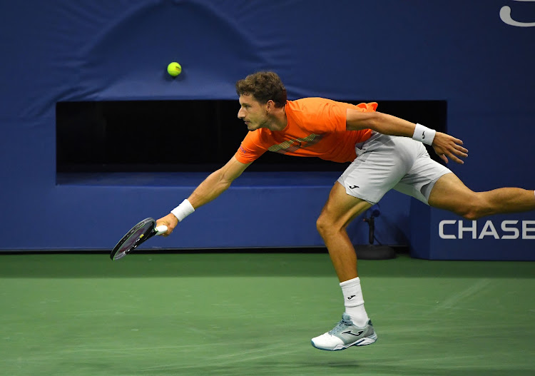 Pablo Carreno Busta tries to return the serve from Denis Shapovalov.