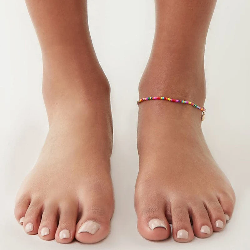 Tornozeleira feminina de conchas com contas coloridas, um acessório de praia elegante e moderno, ideal para realçar seu visual de verão.