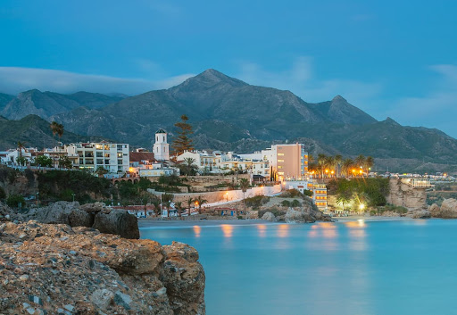 a city with mountains in the background and a body of water in the foreground