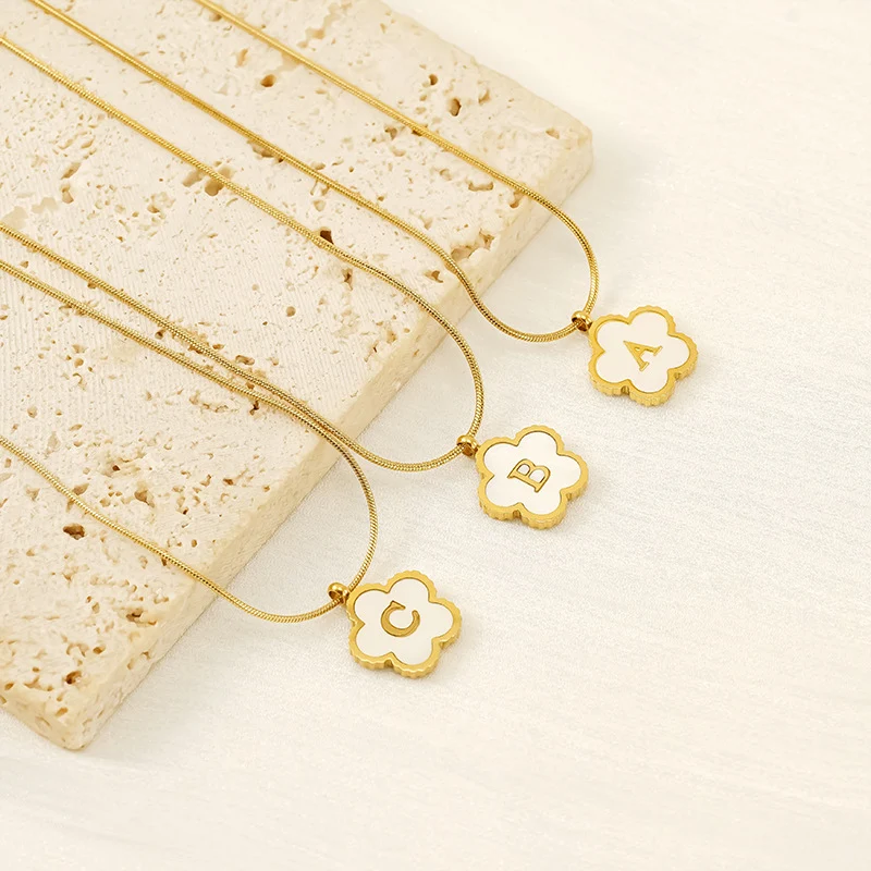 Collier lettre simple en acier inoxydable avec fleur tendance. Un bijou de mode pour femmes, élégant et personnalisable.